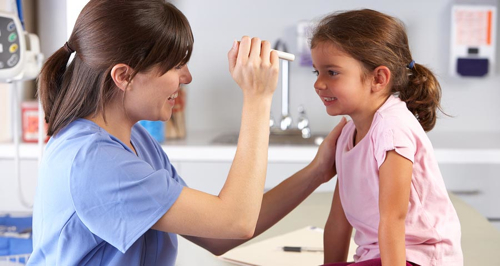 Doctor Examining Child's Eyes In Doctor's Office